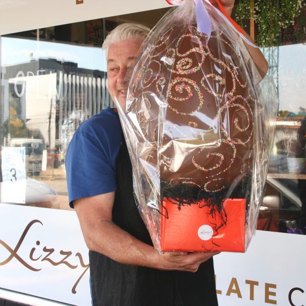 Tim Holding a extra large egg with sprinkles as decorations