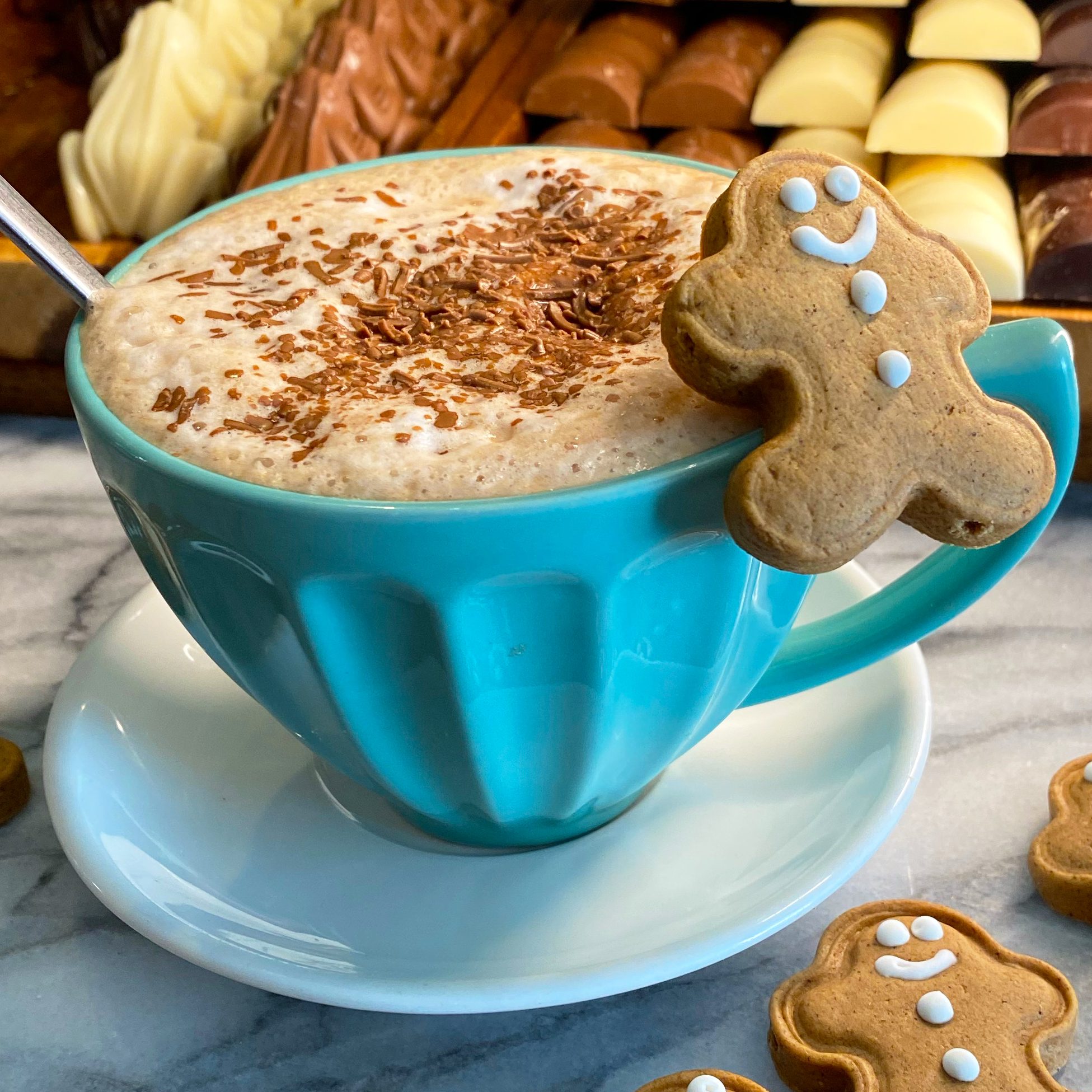 gingerbread hot chocolate in mug with mini gingerbread biscuits surrounding