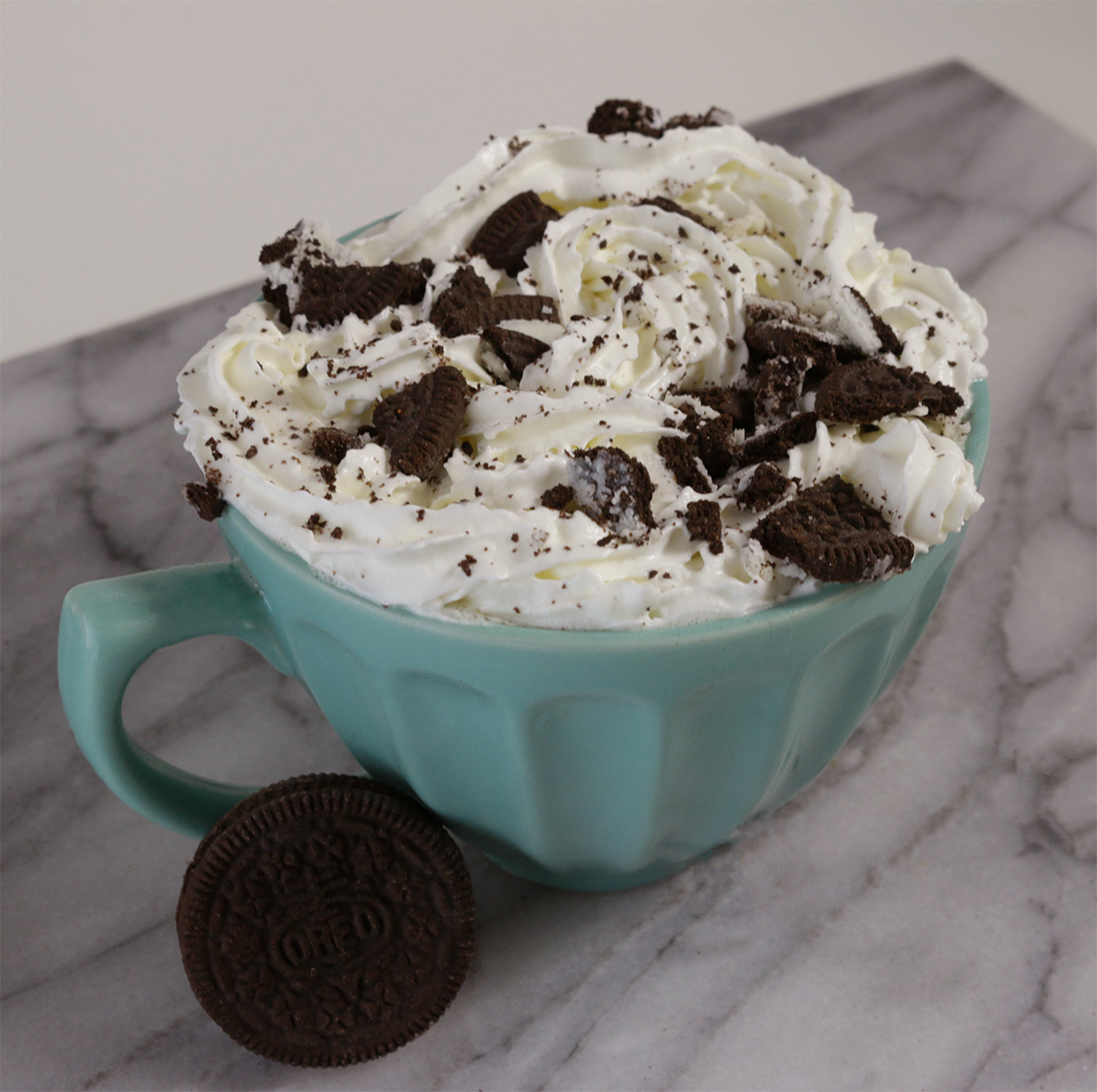 cookies and cream hot chocolate in a mug with oreos broken on top of the drink